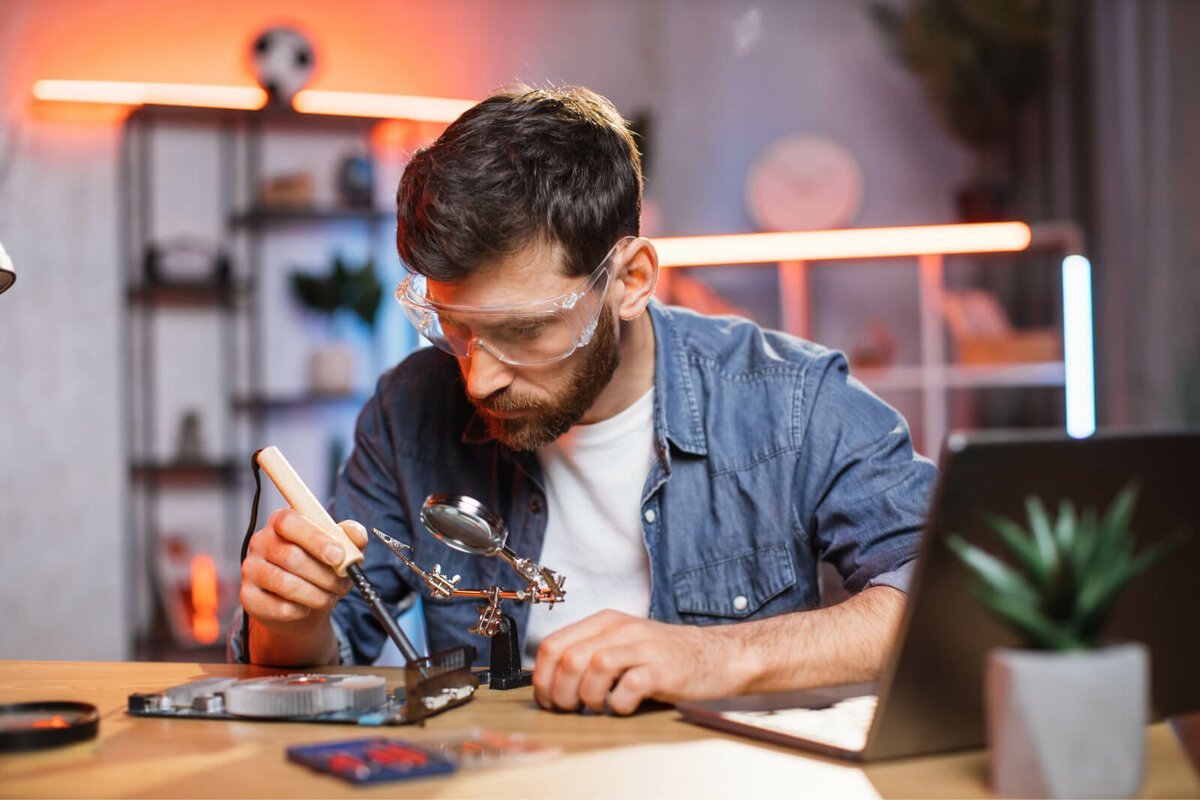 young-man-fixing-display-card-using-soldering-iron